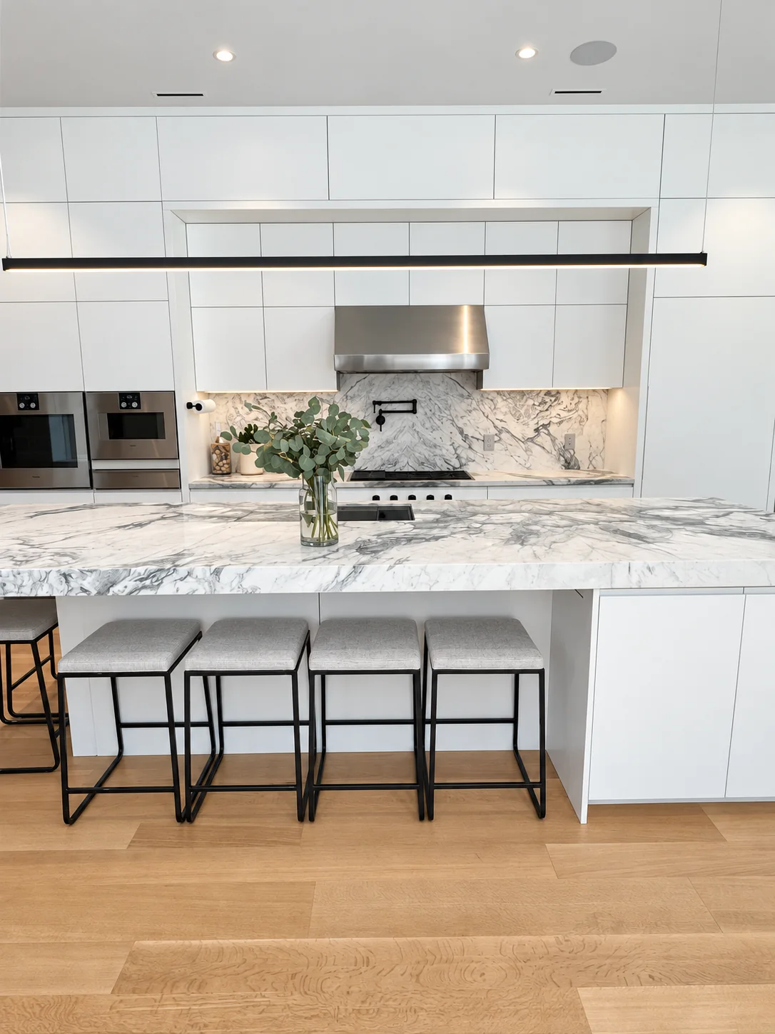 Veined island and white kitchen cabinetry