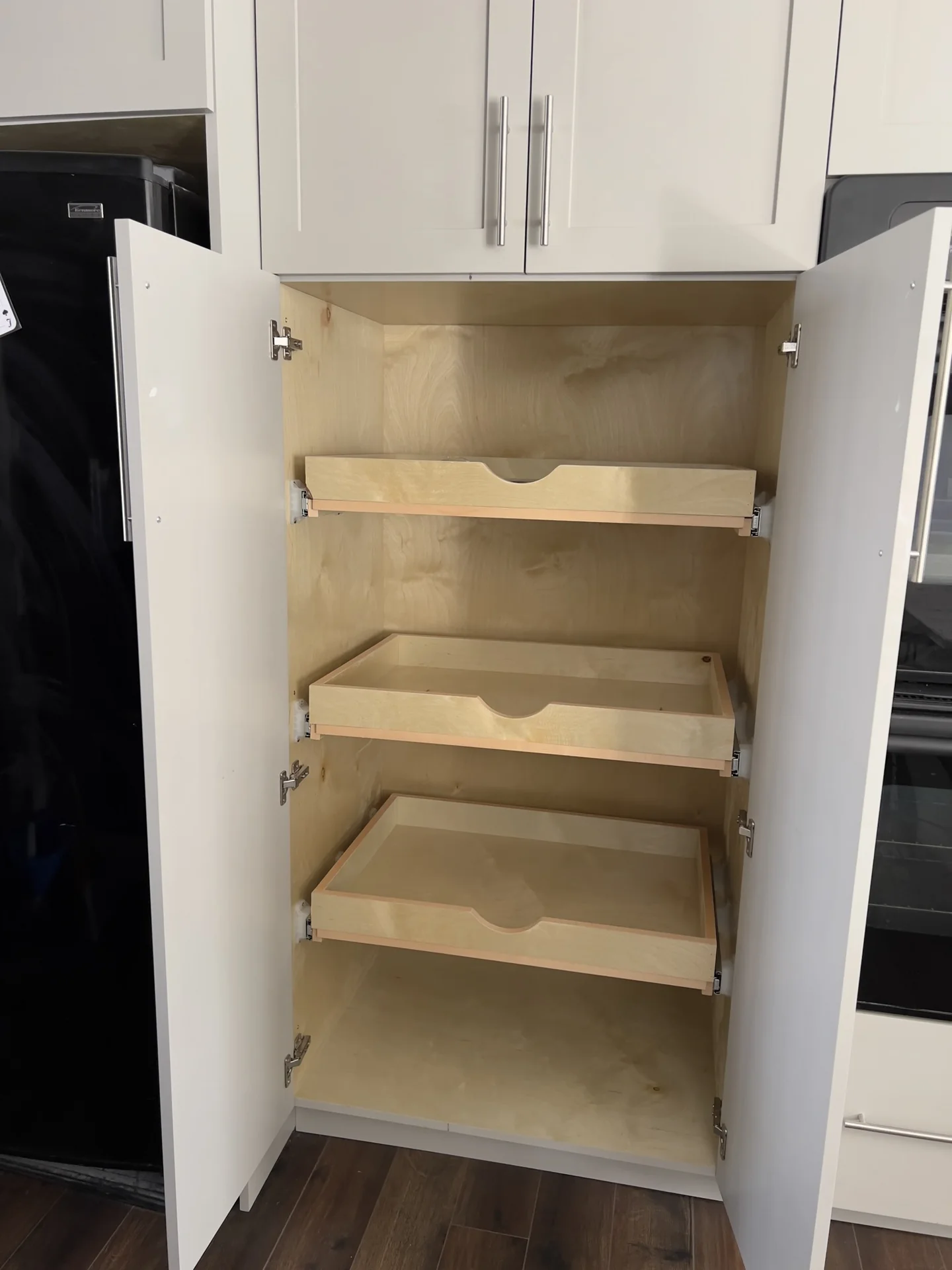 Open tall cabinet with wood pantry pullouts