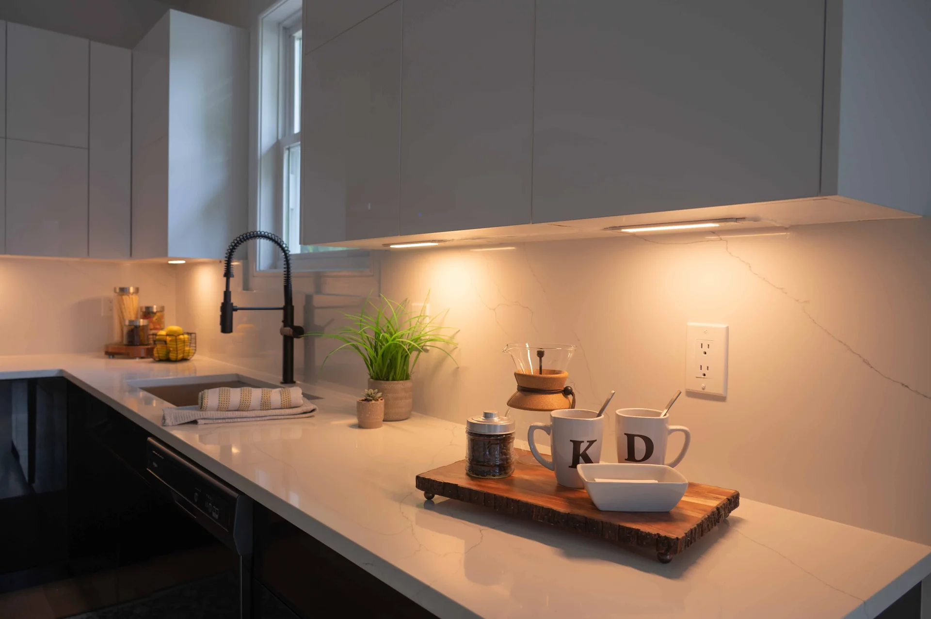 White cabinetry and countertop with warm undercabinet lighting
