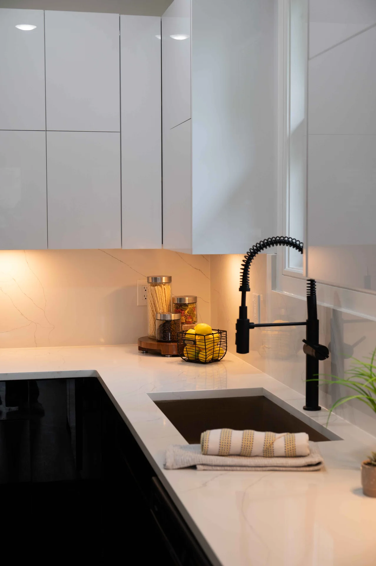 Black faucet and white cabinetry at the kitchen sink